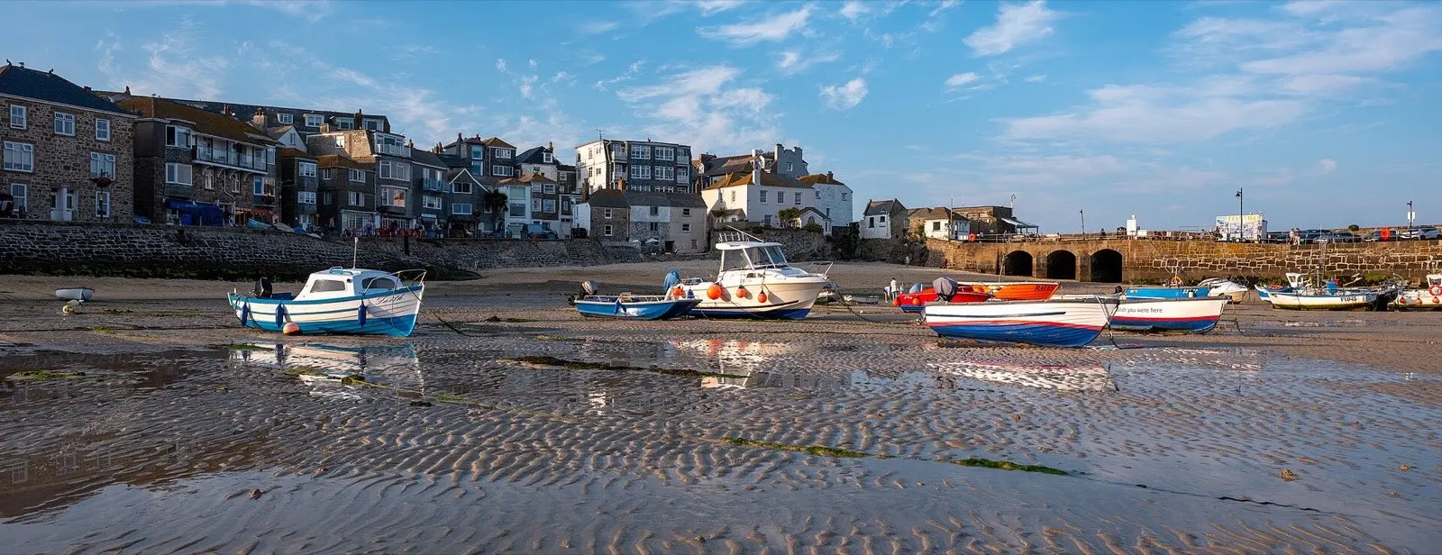 Fishing boats sitting on the sand at low tide in St Ives harbour