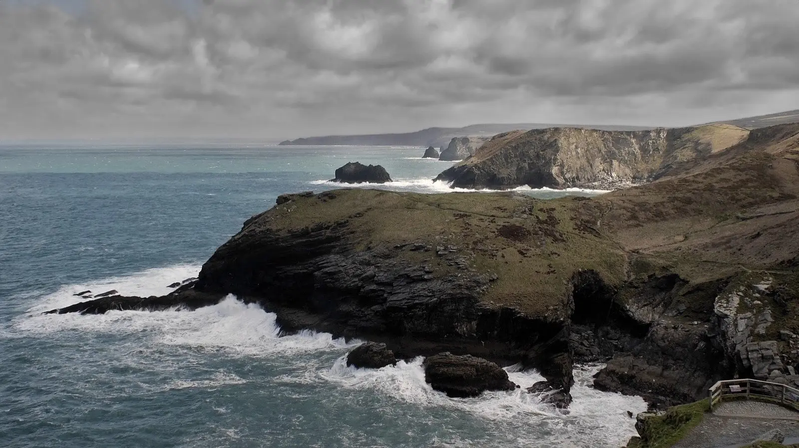 Waves breaking below the cliffs at Tintagel on a stormy day